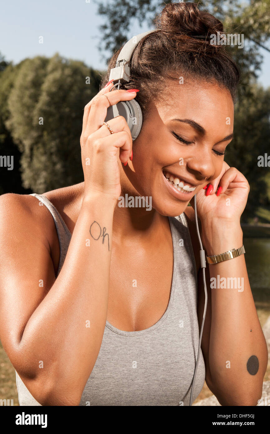 Mujer joven disfruta de la música en sus auriculares Foto de stock