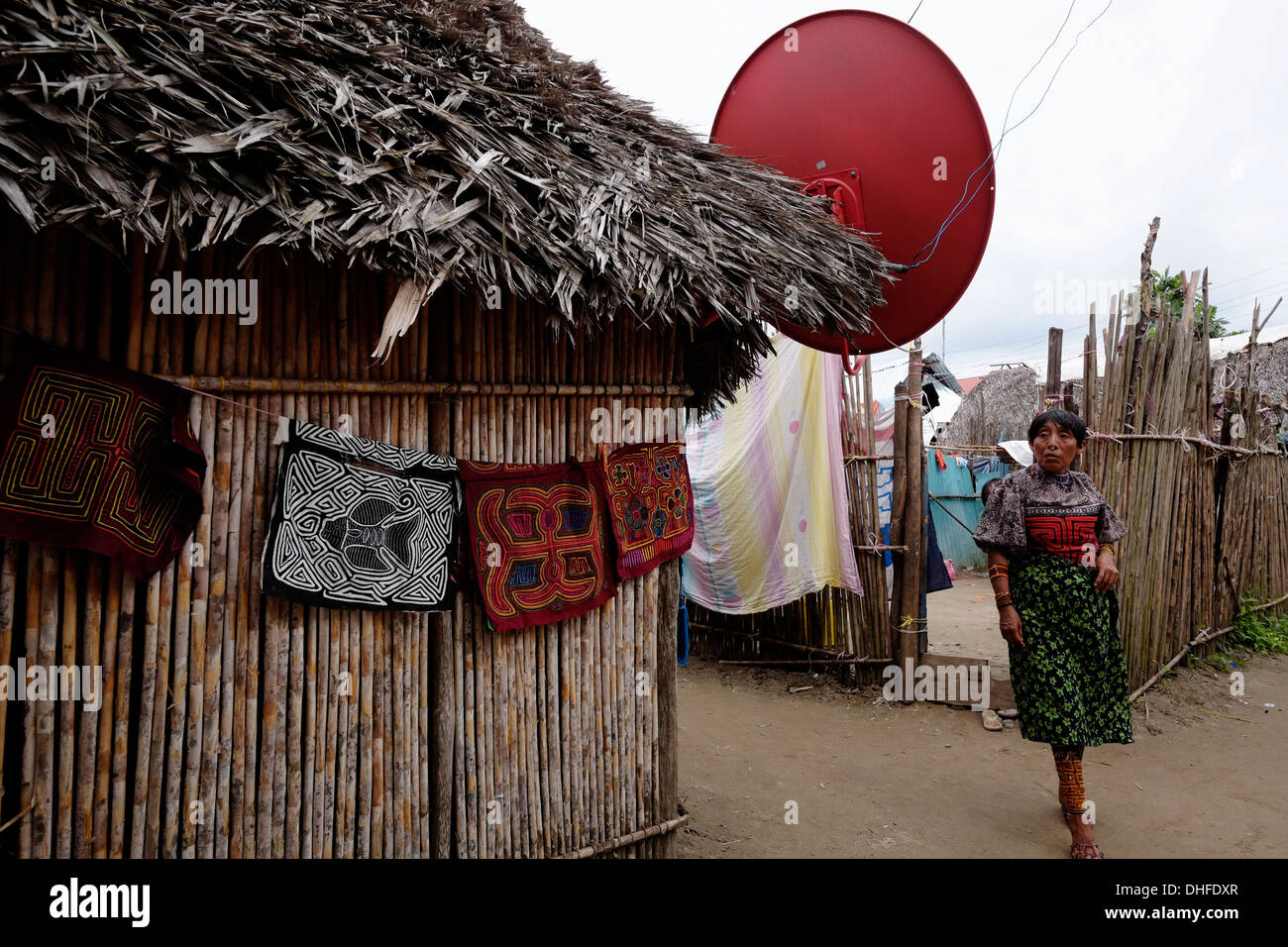 Una mujer del pueblo Guna muestra una selección de tradicionales molas hechas a mano para la venta en su domicilio de Carti Sugtupu island village administrado por Guna nativos conocido como Kuna en la "Comarca" (región) de la Guna Yala, ubicada en el archipiélago de San Blas Blas en el noreste de Panamá frente al Mar Caribe. Foto de stock