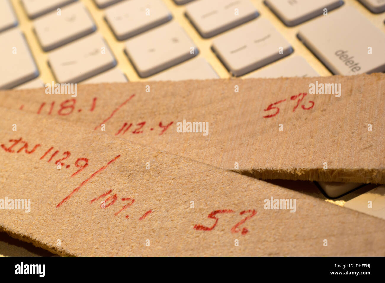 Los cálculos de reducción de Humedad Humedad de madera de madera horno rebanadas poniendo en teclado de ordenador Foto de stock