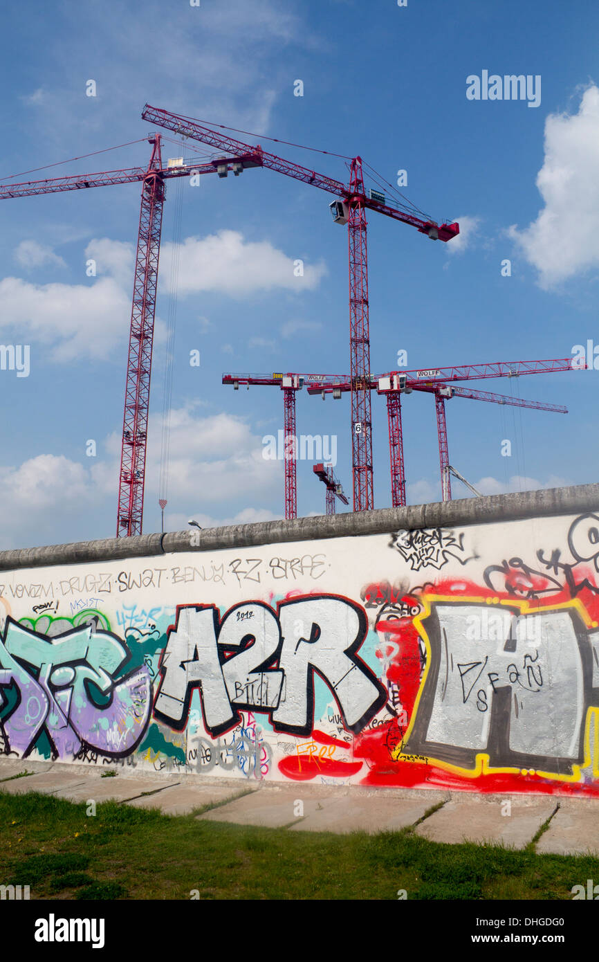 El muro de Berlín la sección restante cubierto de graffiti con grúas de construcción por encima de Berlín ALEMANIA Foto de stock
