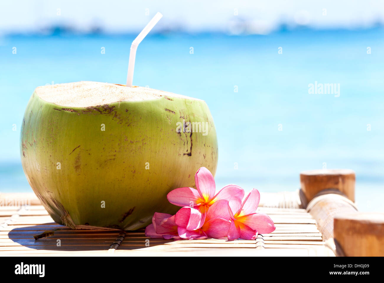 Coco fresco cóctel tropical decorado plumeria en playa blanca Fotografía de  stock - Alamy