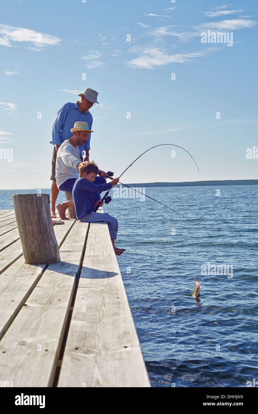 Chico con padre y abuelo, pesca Utvalnas, Suecia Foto de stock