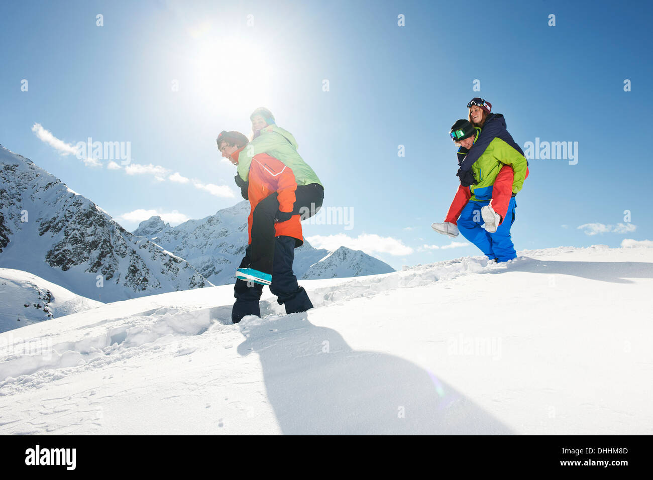 Amigos dando piggy backs en nieve, Kuhtai, Austria Foto de stock