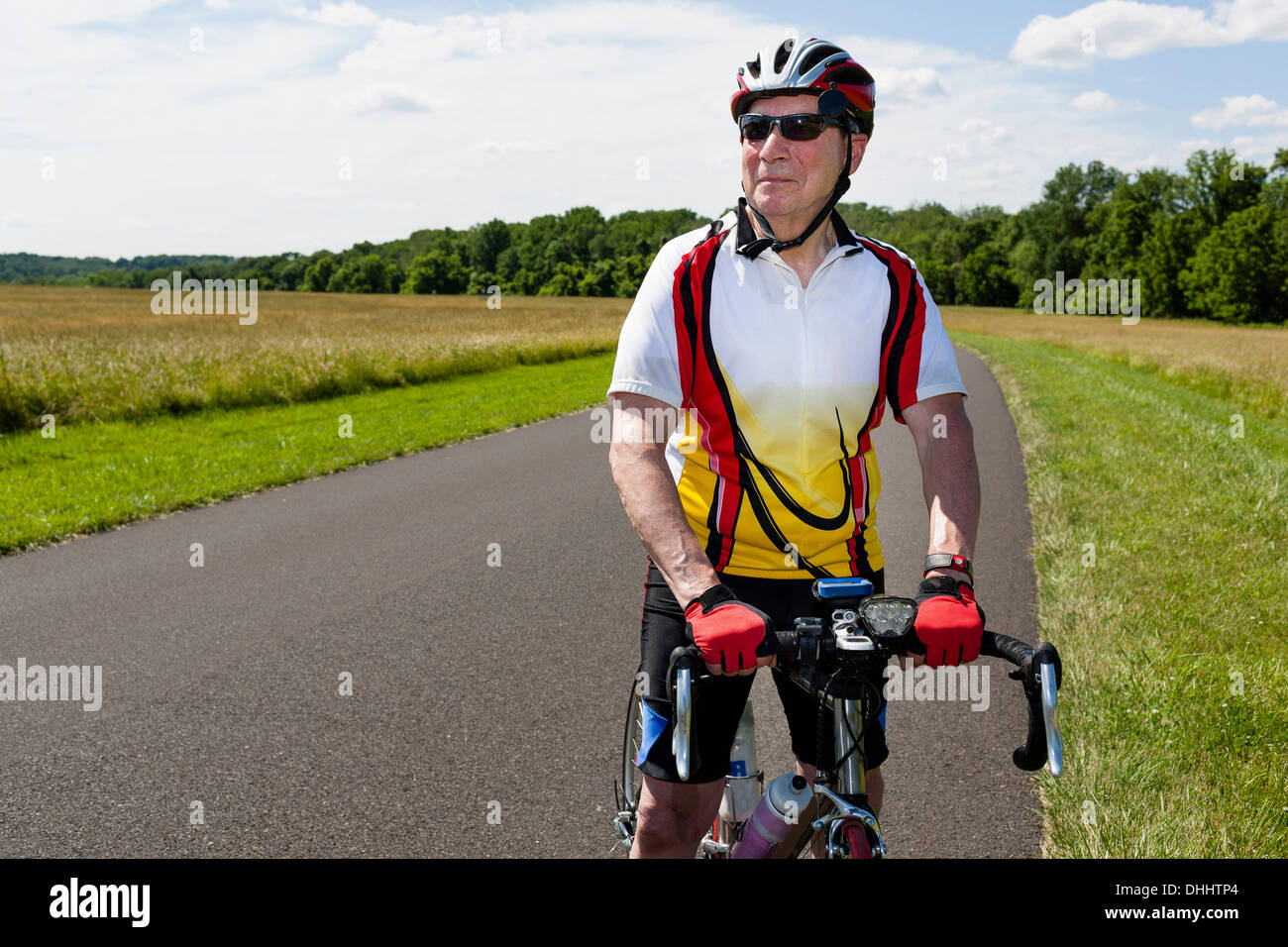 Bicicleta equitación hombre senior a través de campo Foto de stock