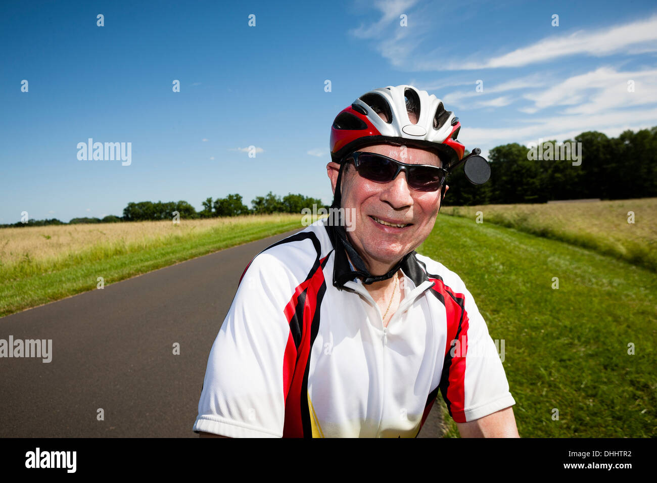 Bicicleta equitación hombre senior a través de campo Foto de stock
