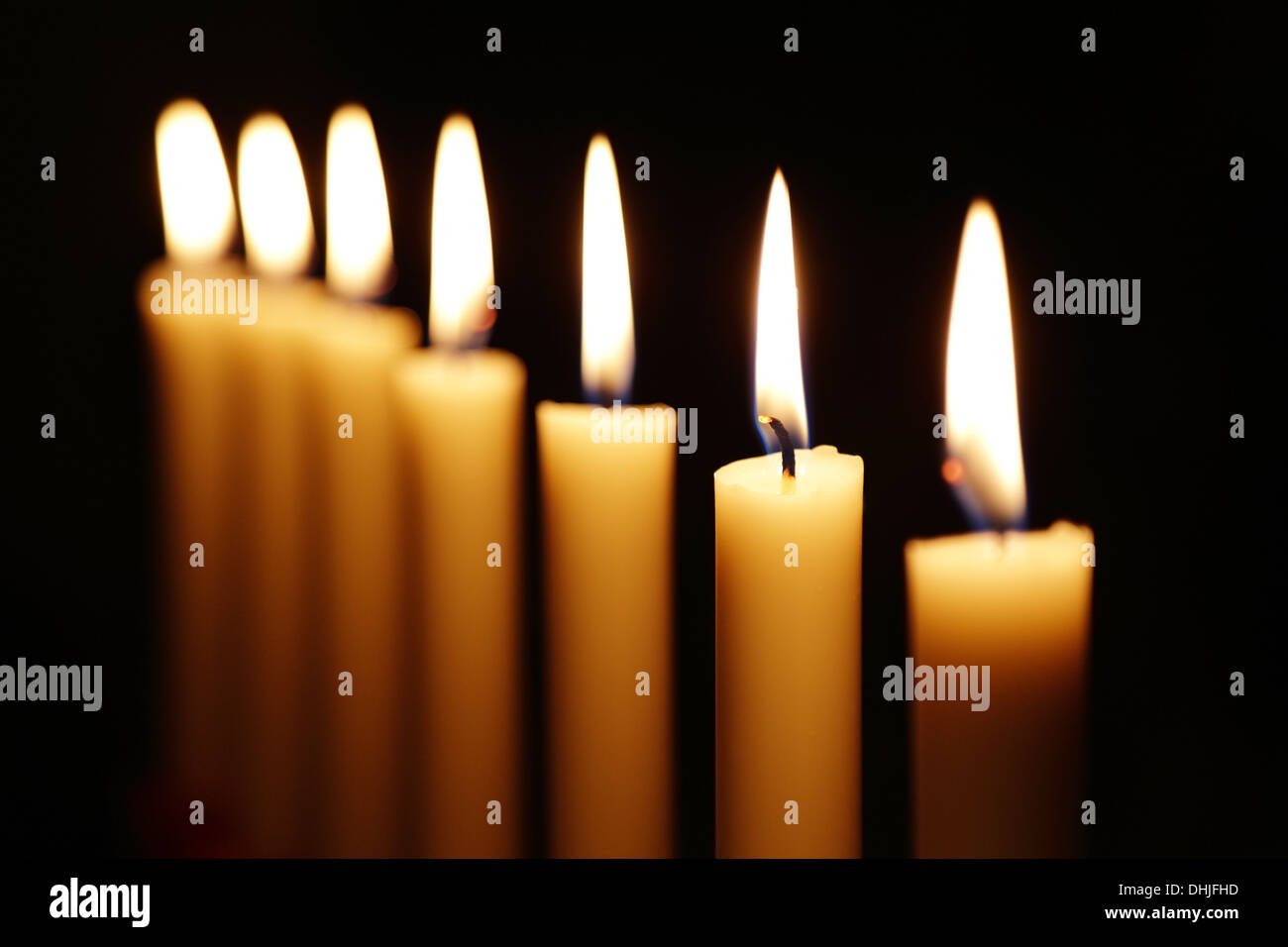 Las velas cortas se queman contra un fondo oscuro. Un montón de velas  pequeñas. No todas las velas están encendidas. Apagado Fotografía de stock  - Alamy
