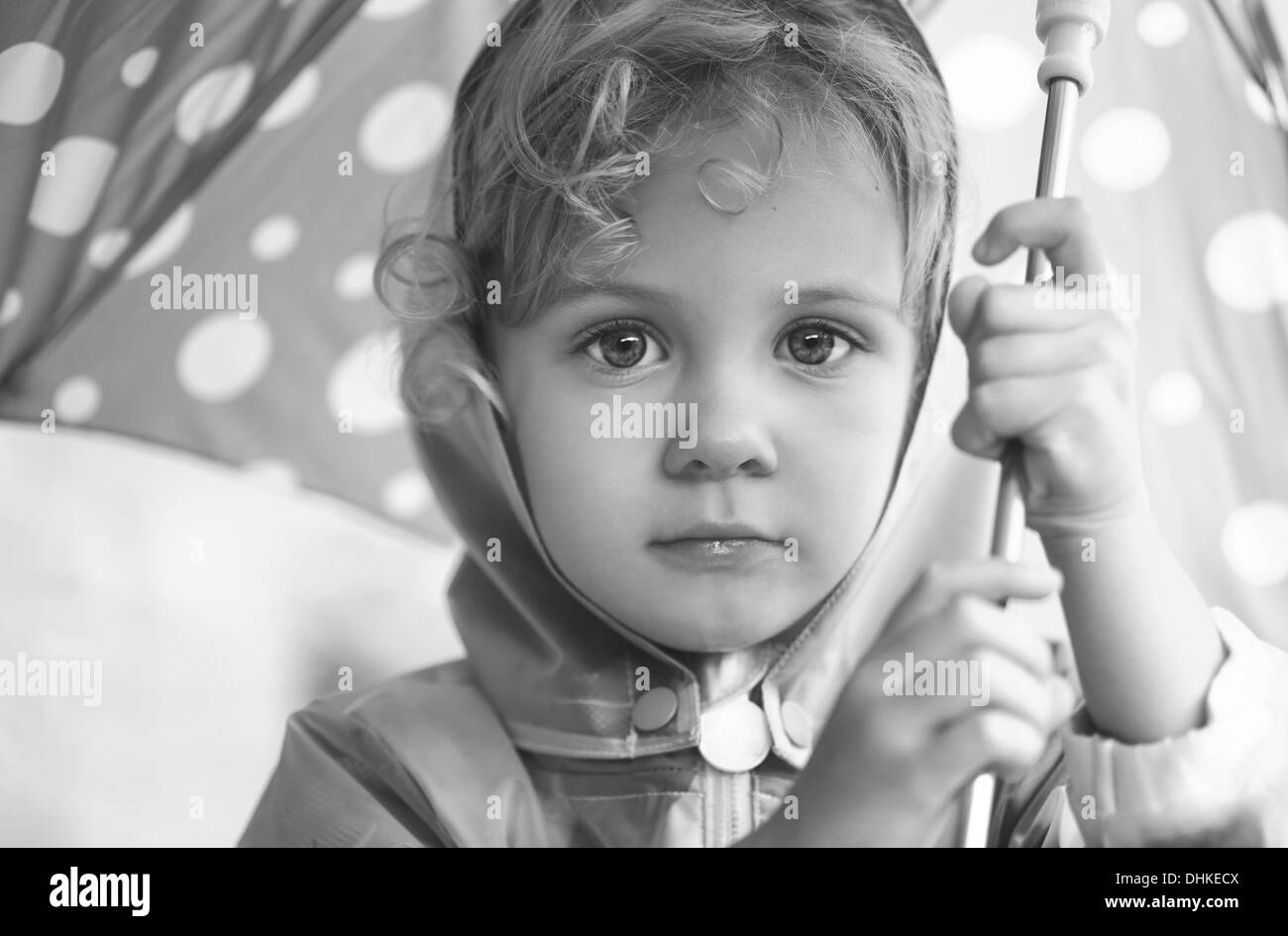 Cute Little Girl sosteniendo un paraguas, cerca de retrato, tintado retro Foto de stock