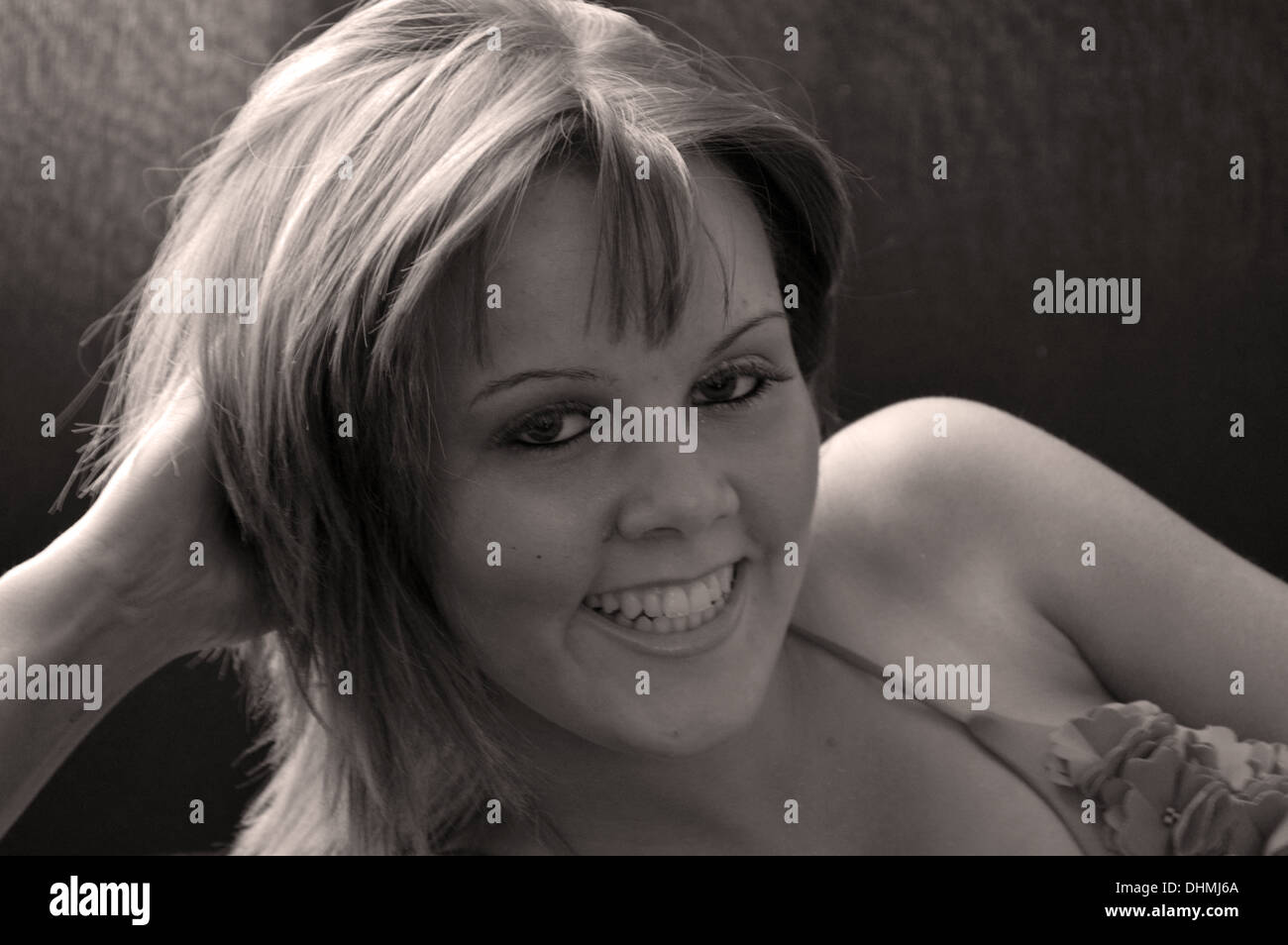 Monocromo retrato de una joven sonriente en una posición de reposo Foto de stock