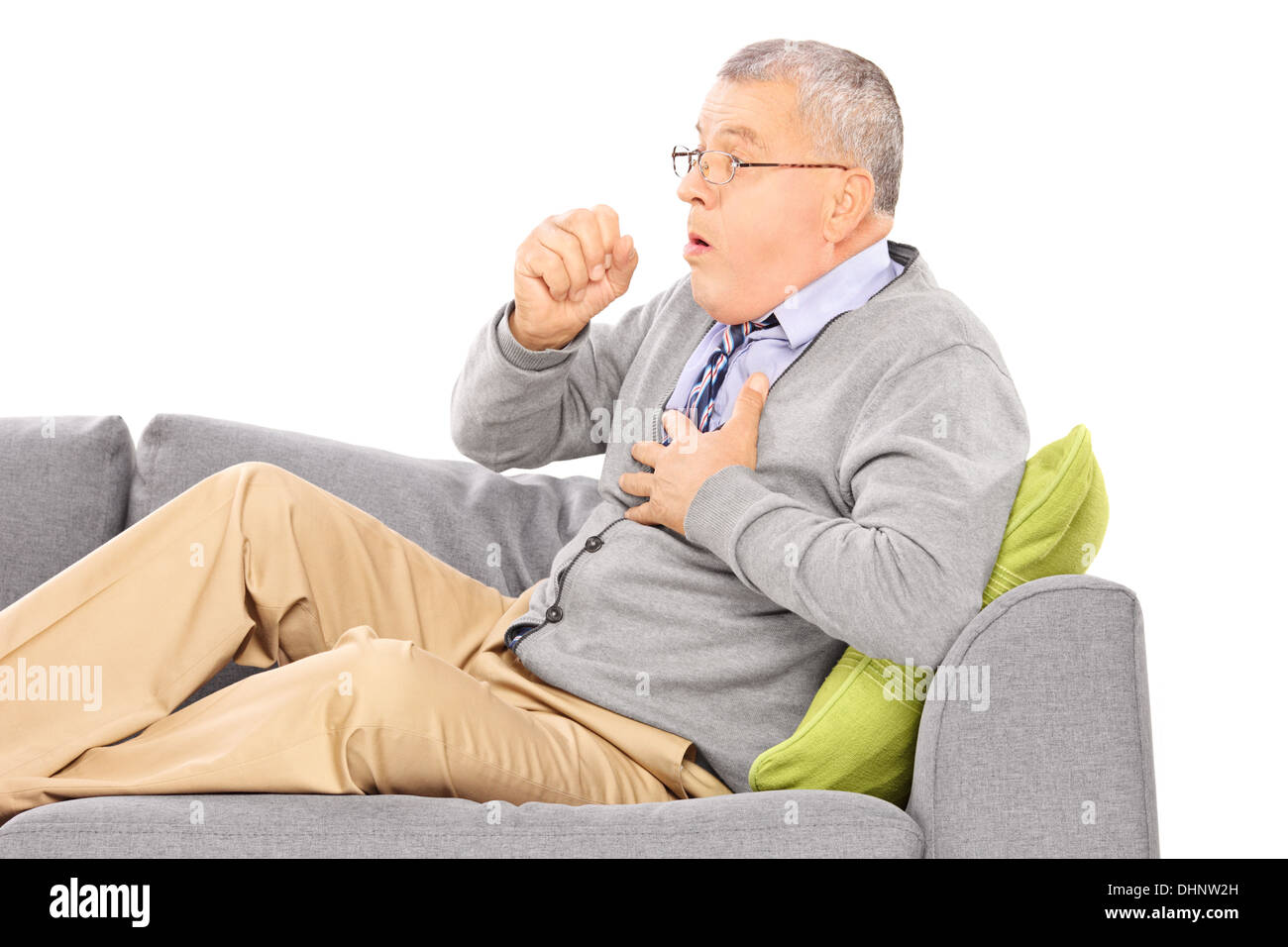 Hombre maduro, sentado en un sofá tos debido a enfermedad pulmonar Foto de stock