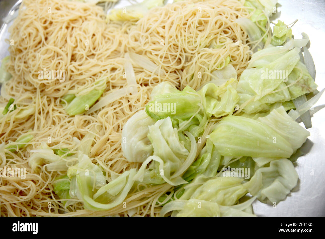 La imagen de fideos mezclados con las verduras en una sartén. Foto de stock