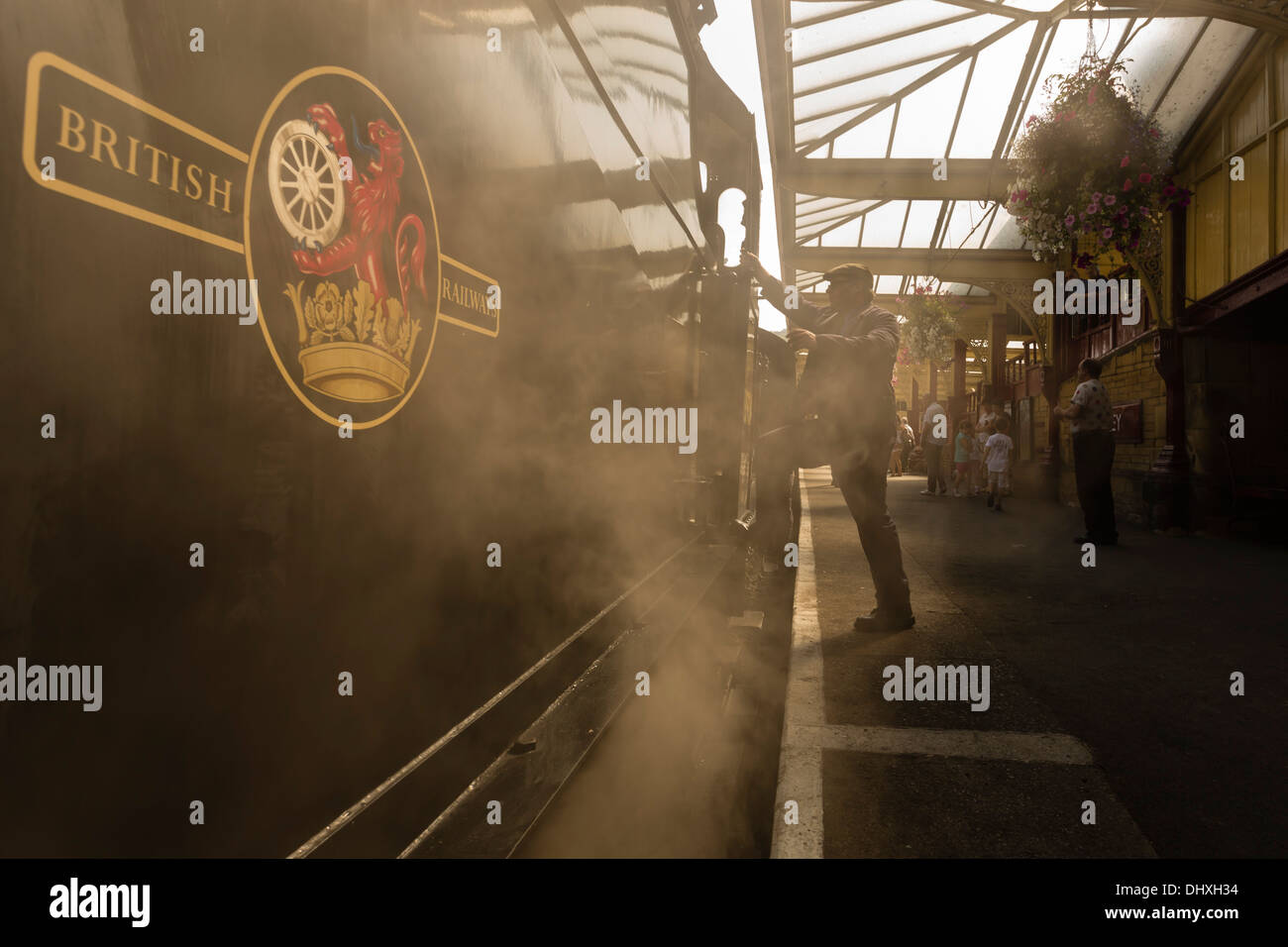 Conductor subirse a una locomotora a vapor en Keighley Station en el Haworth y Worth Valley Railway. Foto de stock