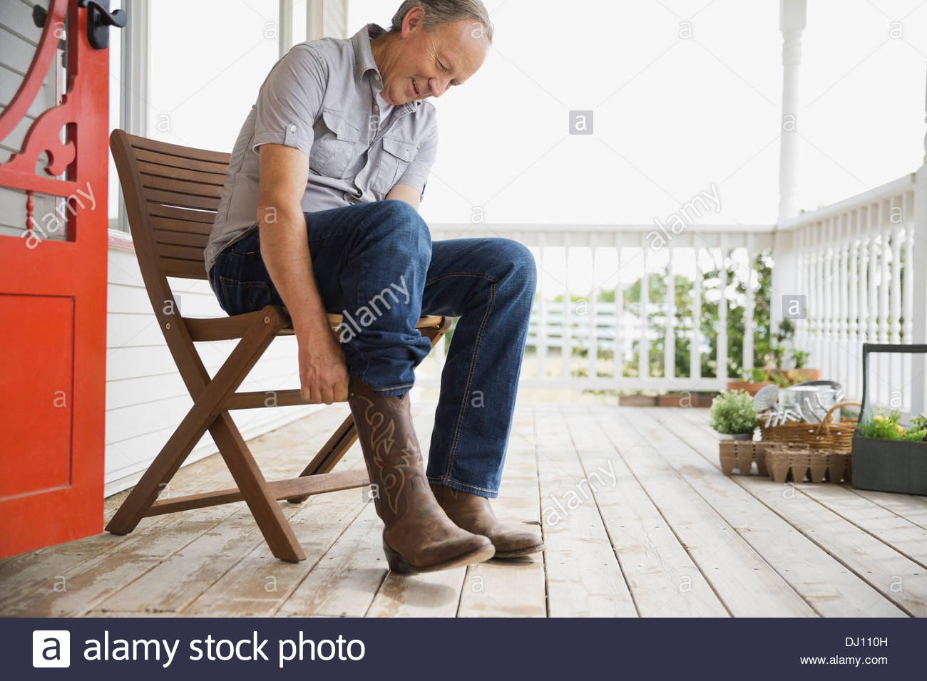 El hombre poniendo en botas de vaquero Foto de stock