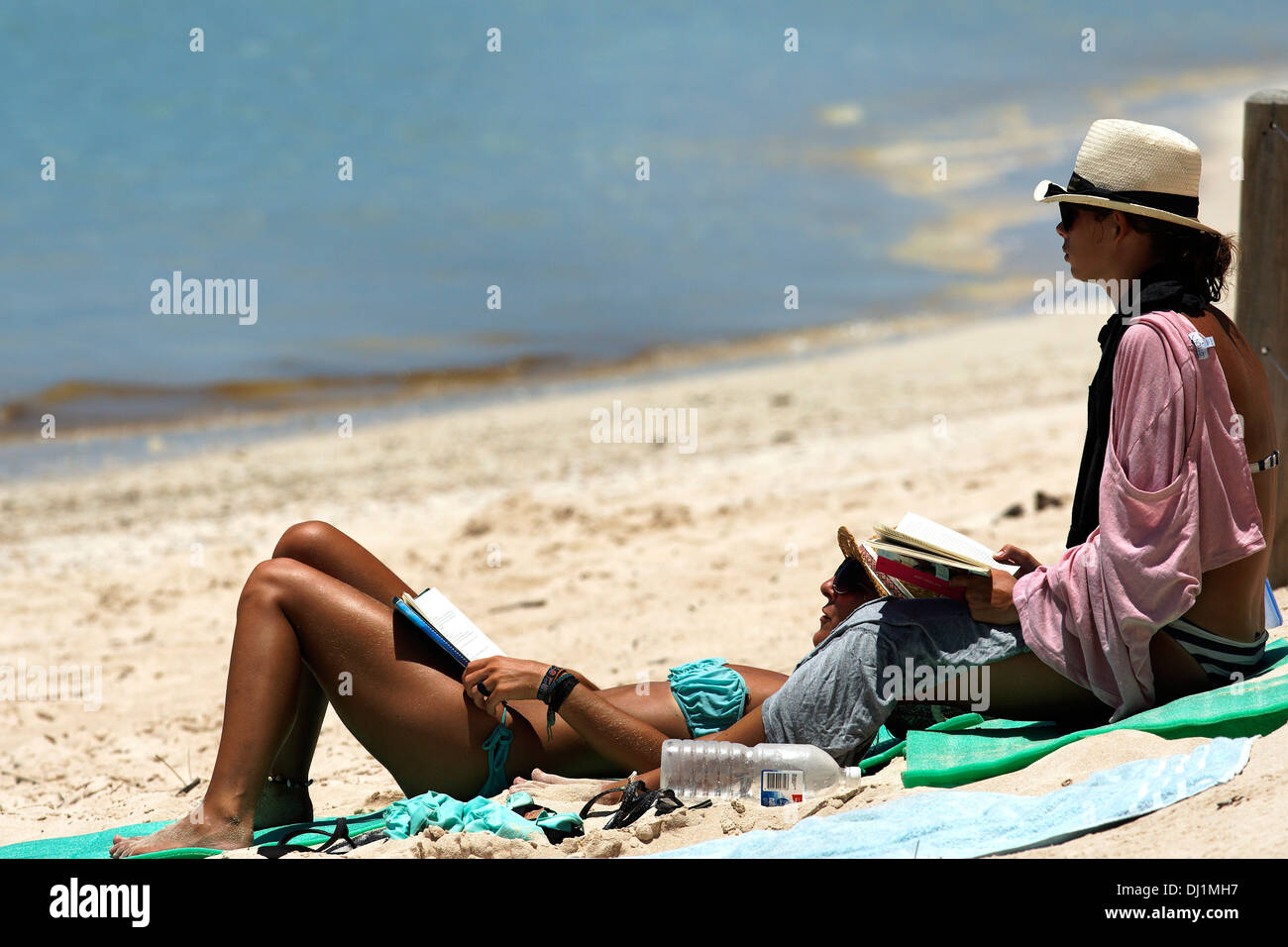 Lectura de los bañistas en la playa de arena blanca, el Parque Nacional de Cape Range, Exmouth Australia Occidental Foto de stock
