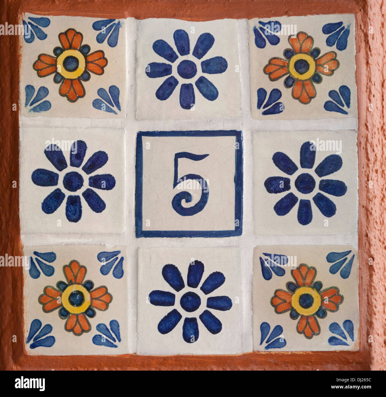 El número 5 en azulejos pintados a mano entre otros azulejos florales Foto de stock