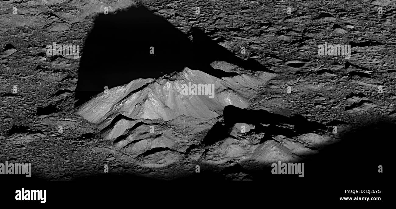 Pico central del cráter Tycho complejo, proyecta una larga sombra oscura cerca del amanecer local en este espectacular lunarscape. Foto de stock