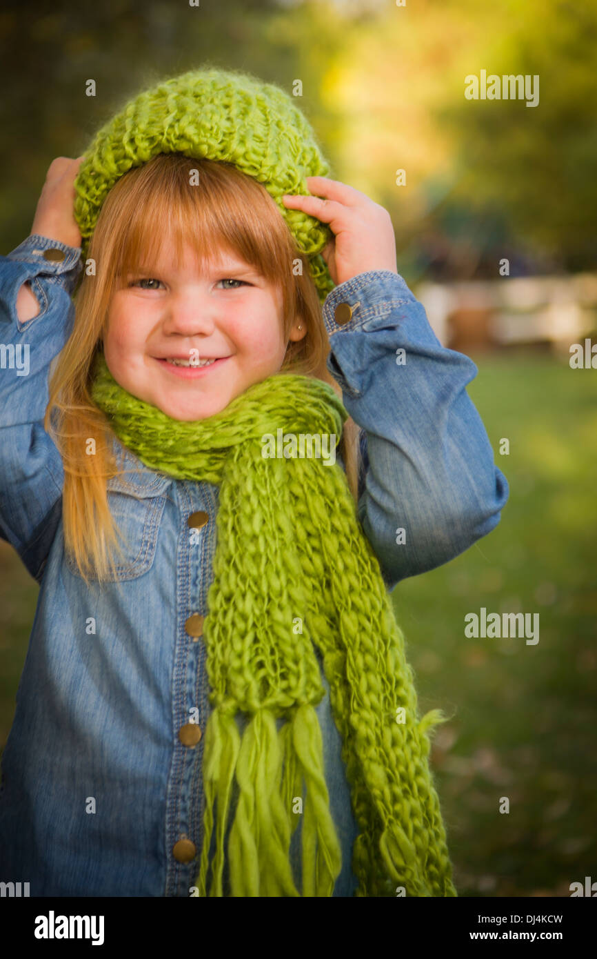 Cute sonriente joven vestida de bufanda verde y sombrero posando para un  retrato fuera Fotografía de stock - Alamy