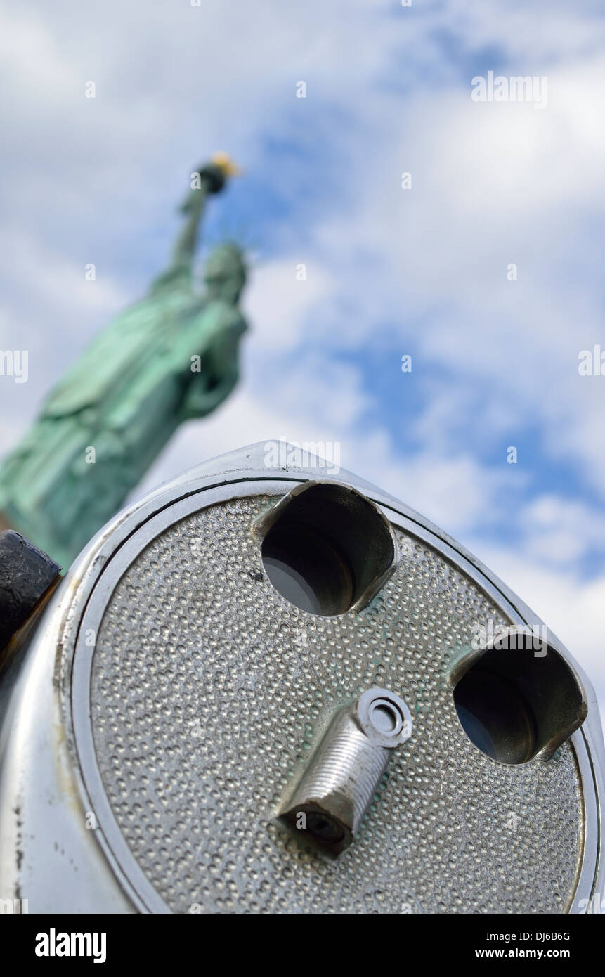 La estatua de la libertad detrás de un rostro visor binocular con monedas Foto de stock
