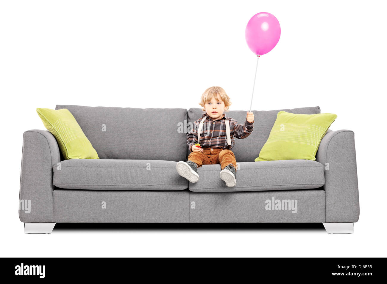 Cute little boy sentado en el sofá con un globo de aire caliente Foto de stock