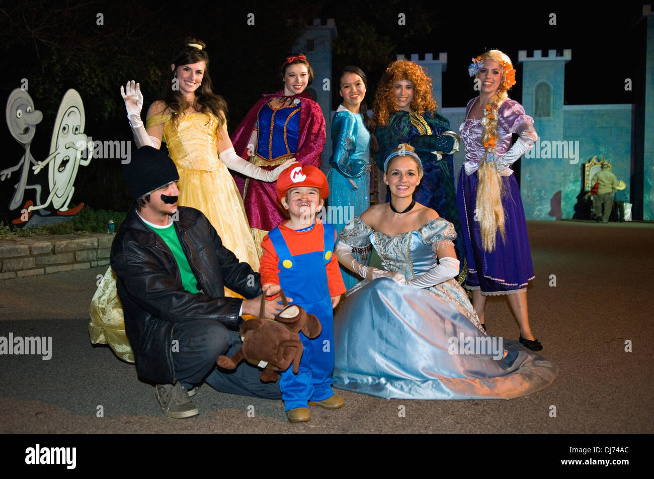 Infante vestido como Mario con su padre y las Princesas de Disney en el Louisville Zoo Halloween Party en Louisville Kentucky Foto de stock