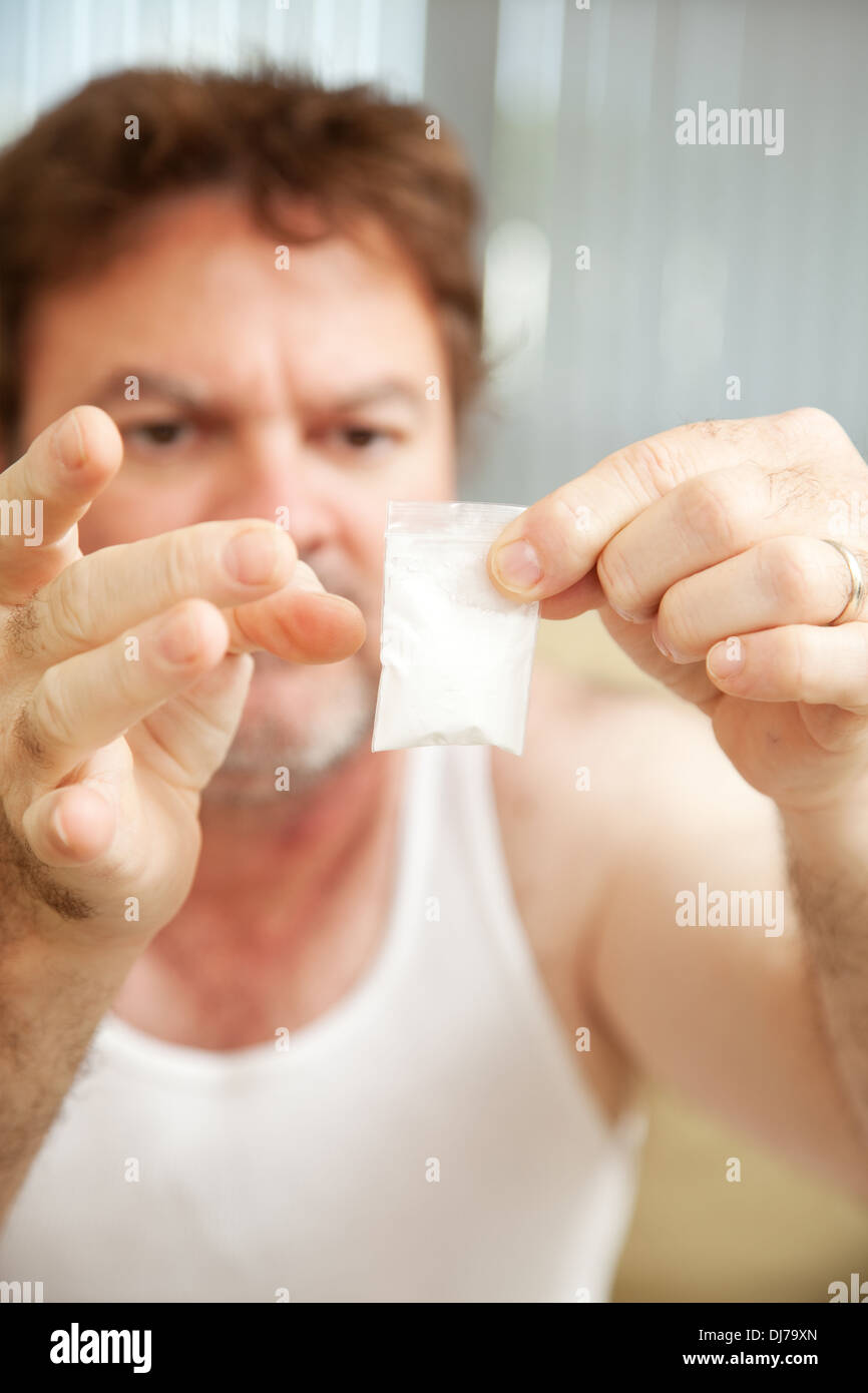 Drogadicto sosteniendo un gramo de cocaína. **La dramatización sin
