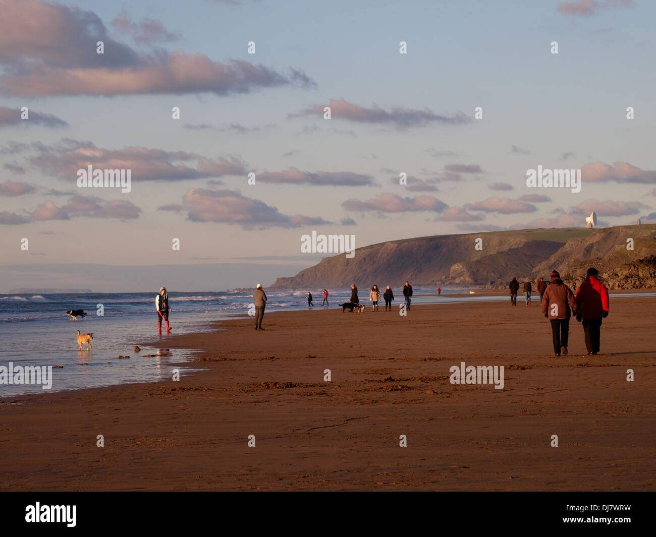 La gente caminando en la playa por la tarde en invierno, Bude, Cornualles, en el REINO UNIDO Foto de stock