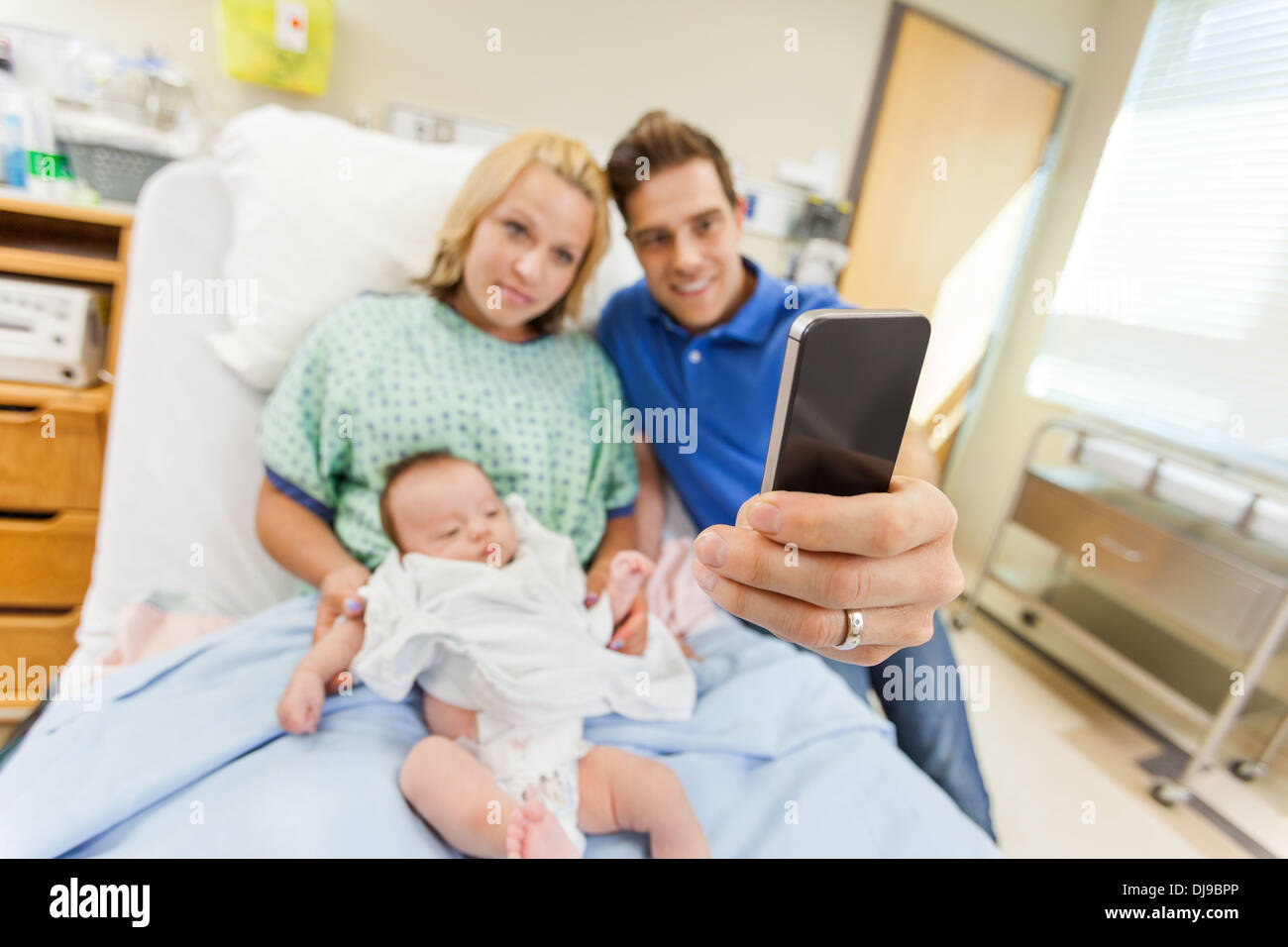 El hombre con la mujer y teniendo Babygirl Autorretrato a través de la celda Pho Foto de stock