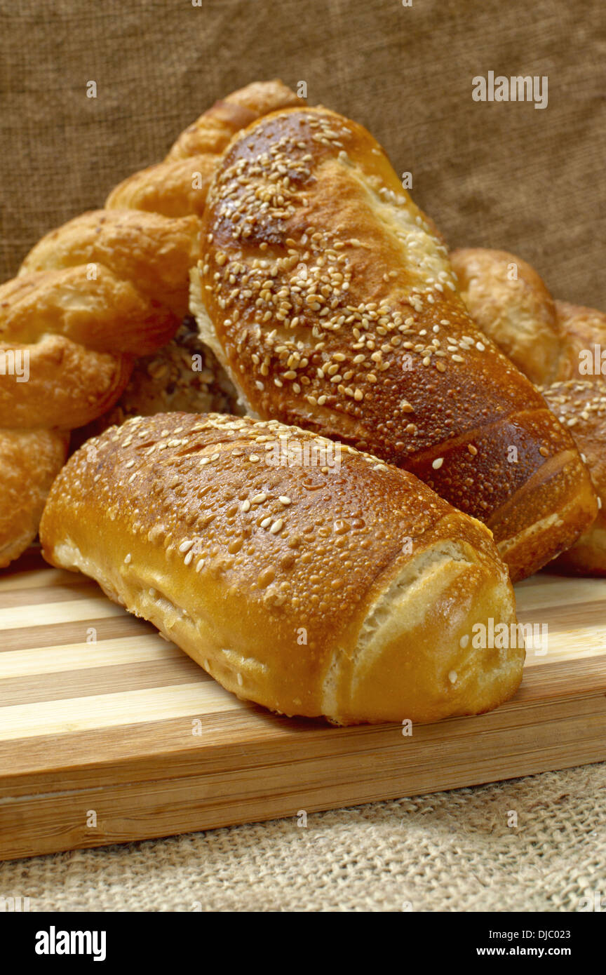 Sabroso fresco y crujiente pan casero caliente sobre una placa de madera. Foto de stock