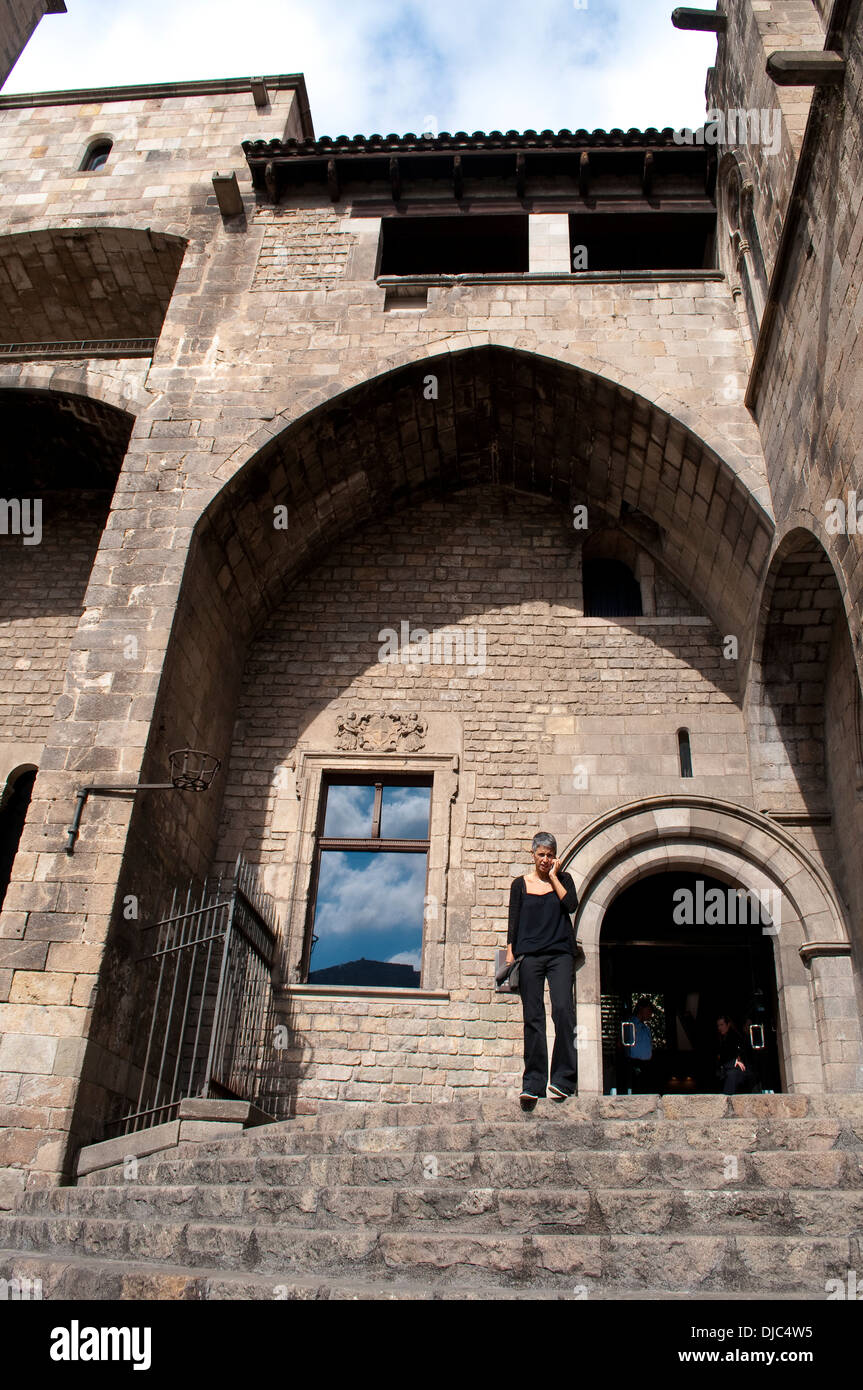 Mujer hablando por móvil, el Palau Reial Major, Museo de Historia de la ciudad de Barcelona, la Plaça del Rei, Barcelona, España Foto de stock