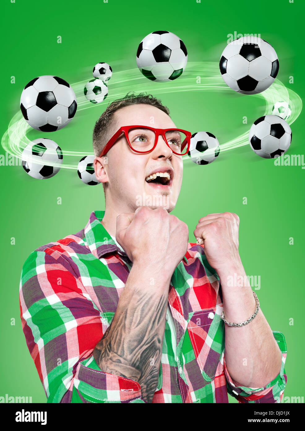 Joven con balones volando alrededor de su cabeza, compuesto Foto de stock