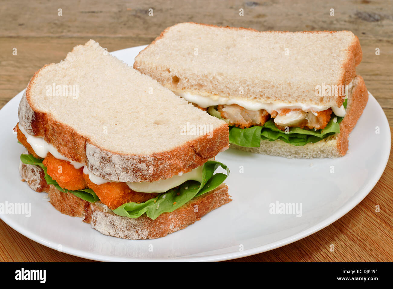 Sándwich de Dedos de Pescado fresco en un plato para servir de blanco Foto de stock