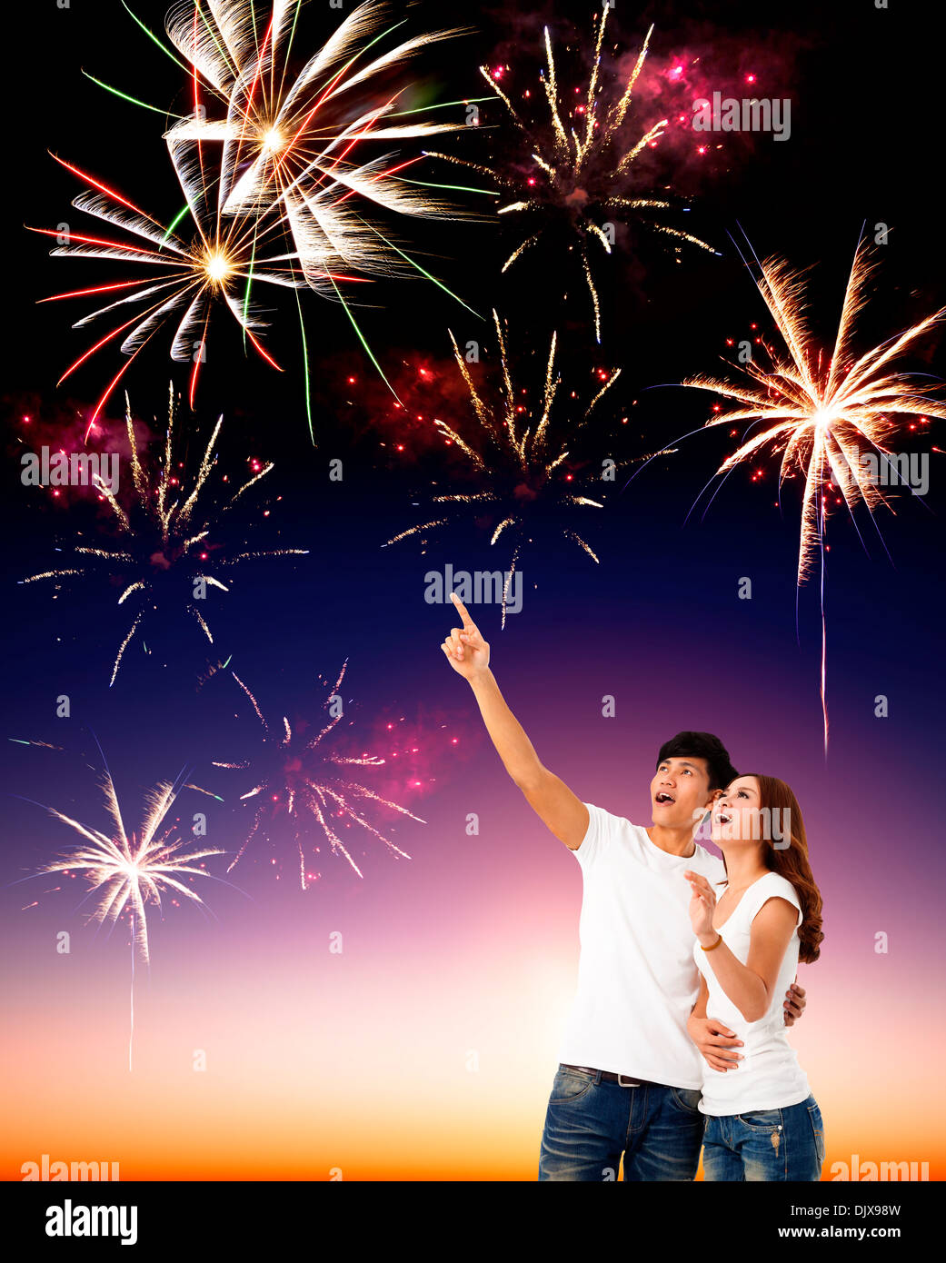 Joven pareja feliz viendo los fuegos artificiales en el cielo Foto de stock