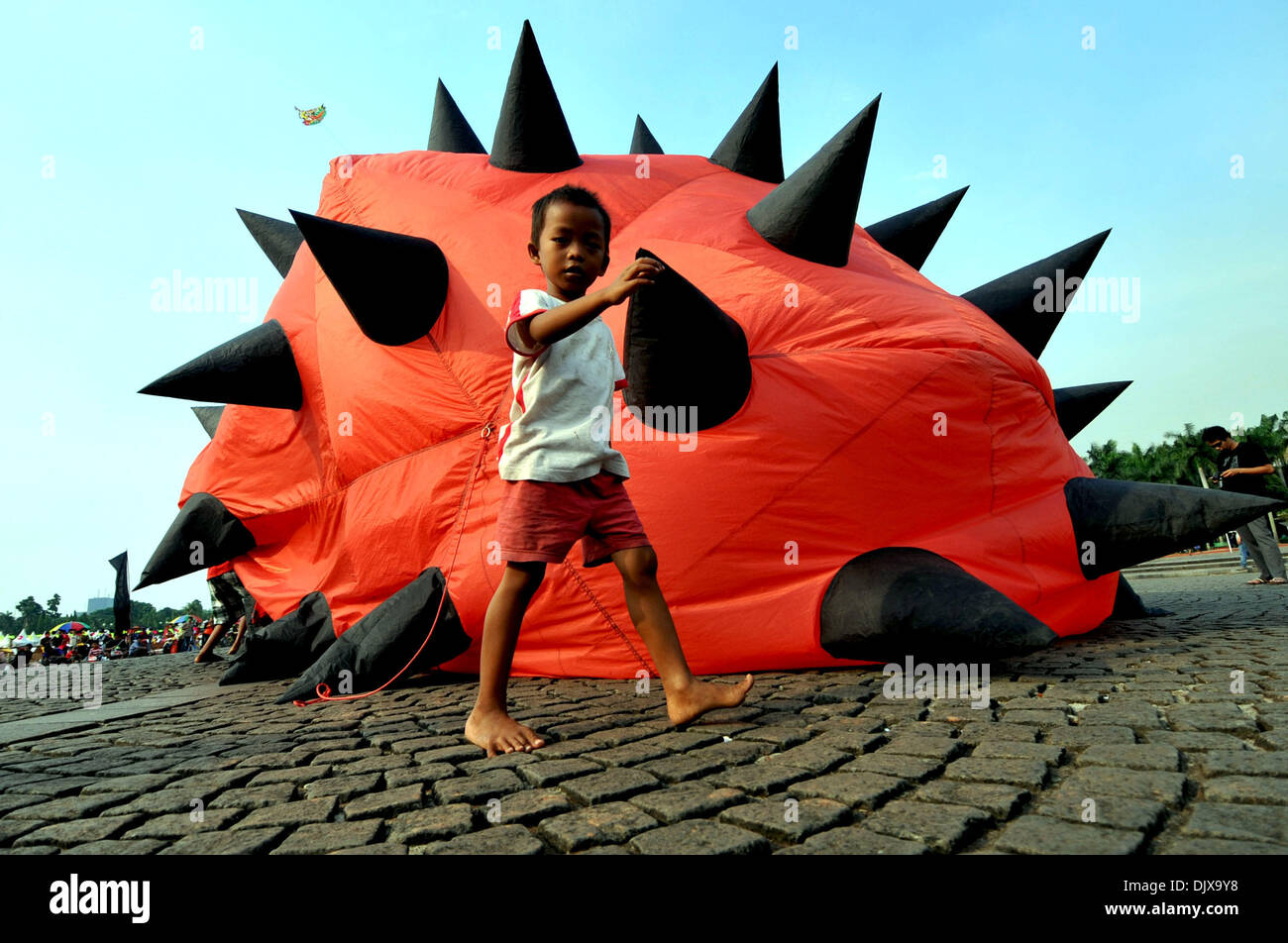 Yakarta, Indonesia. El 1 de diciembre, 2013. Un niño camina pasado un cometa durante el Festival Internacional de Cometas de Yakarta de 2013 en Yakarta, Indonesia, el 30 de noviembre de 2013. Los dos días de festival se inauguró el sábado, con la participación de 18 países y regiones. Crédito: Agung Kuncahya B./Xinhua/Alamy Live News Foto de stock