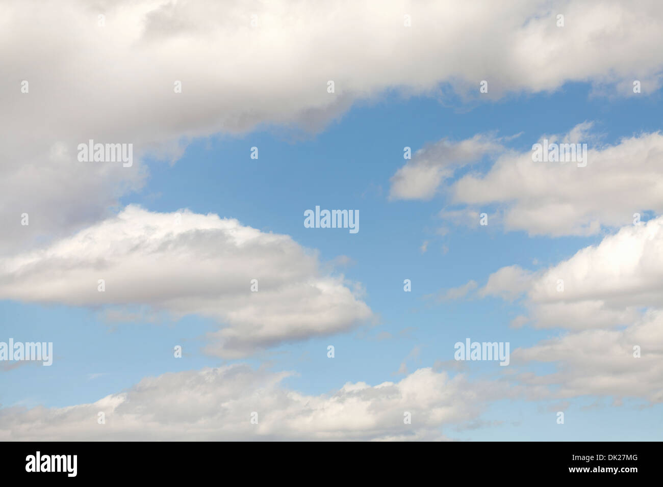 Nubes blancas mullidas en el soleado cielo azul Foto de stock