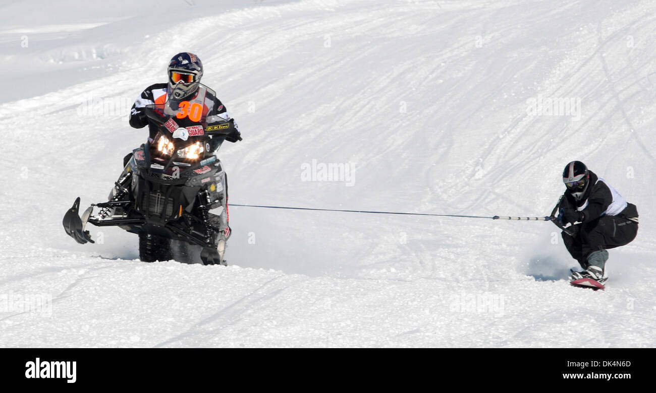 Abril 9, 2011 - Cumbre Lago, AK, EE.UU. - David Lammle cuclillas en el  extremo de la cuerda en su tabla de snowboard, Sottosanti snowmachiner Ryan  le da el gas como él