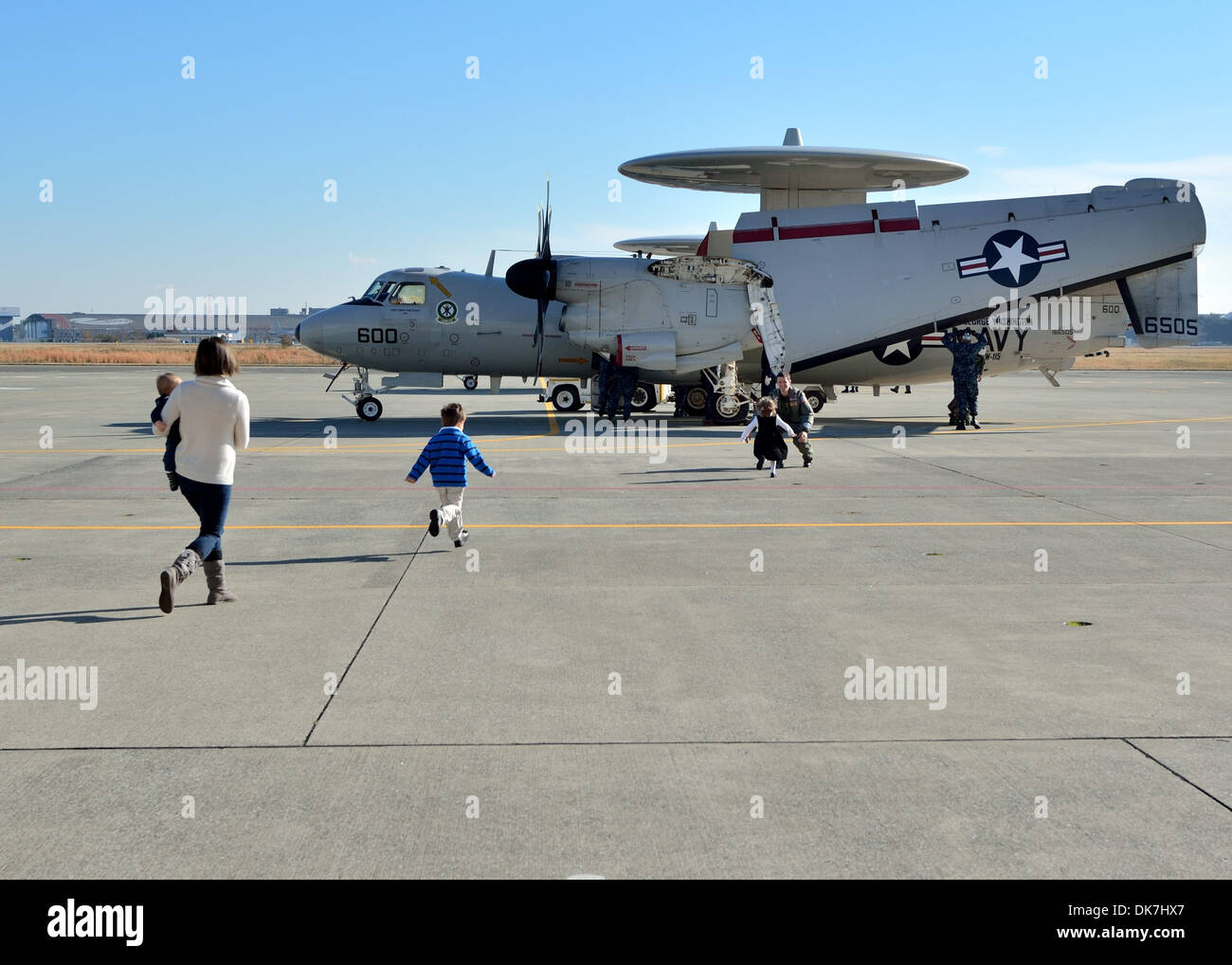 Escuadrón de Alerta Temprana Aerotransportada (VAW) 115 la teniente comodoro piloto. Stephen Yenias es saludado por su esposa e hijos durante un regreso ce Foto de stock