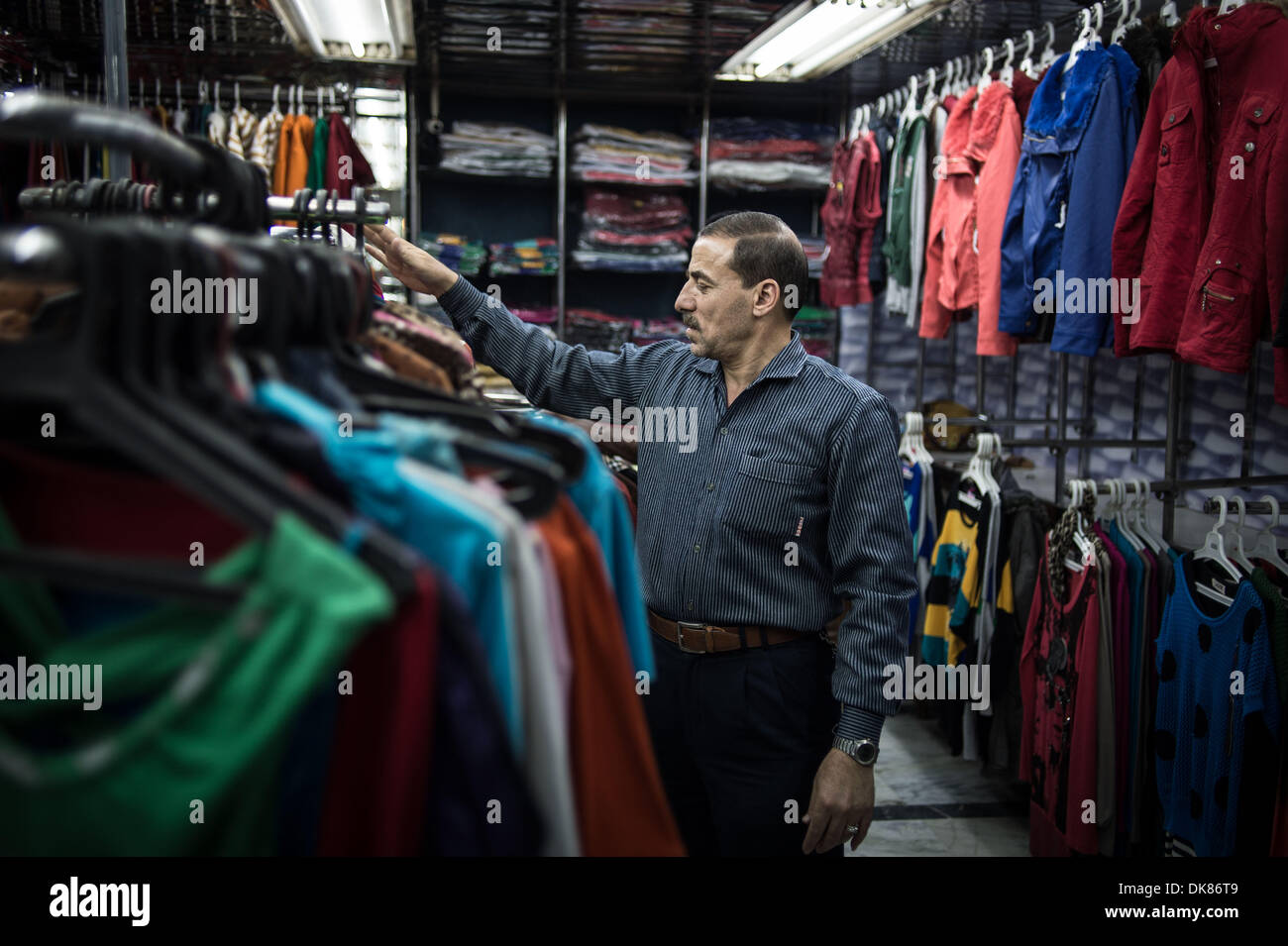 la nieve repertorio Cirugía El Cairo, Egipto. 3º de diciembre de 2013. Salesclerk Ali (R) organiza la  ropa en una tienda de tela, cerca de la plaza Tahrir. Ali ha estado  trabajando durante los 21 años