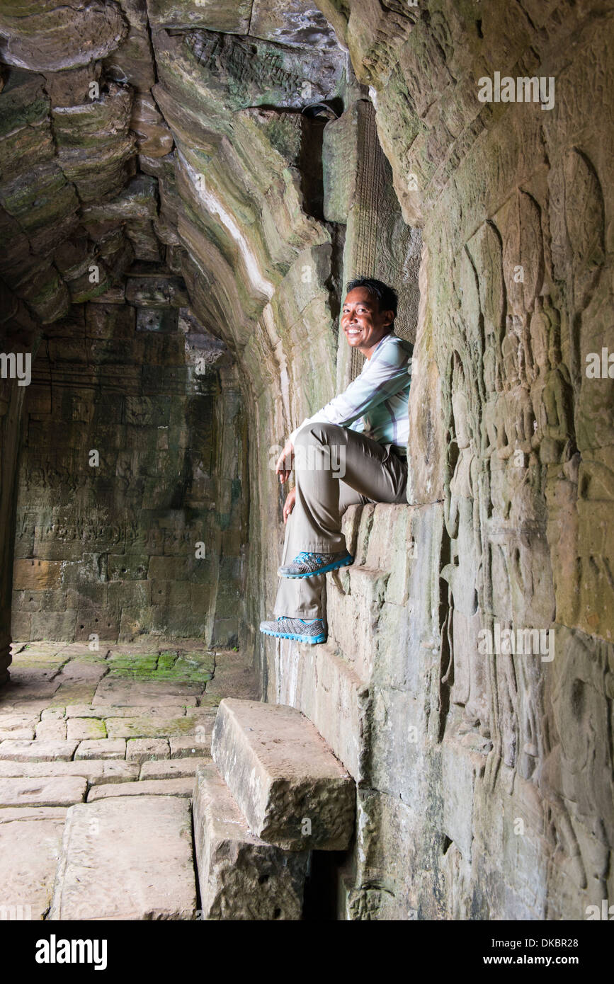 El hombre sentado en el interior de templo Bayon, Siem Reap, Camboya Foto de stock