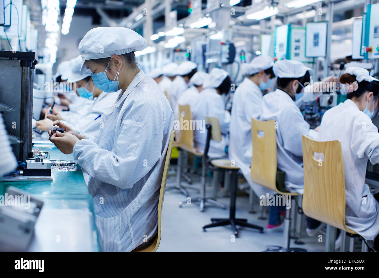 Grupo de Trabajadores de la fábrica de fabricación de piezas pequeñas en  China, el uso de ropa protectora, sombreros y máscaras Fotografía de stock  - Alamy