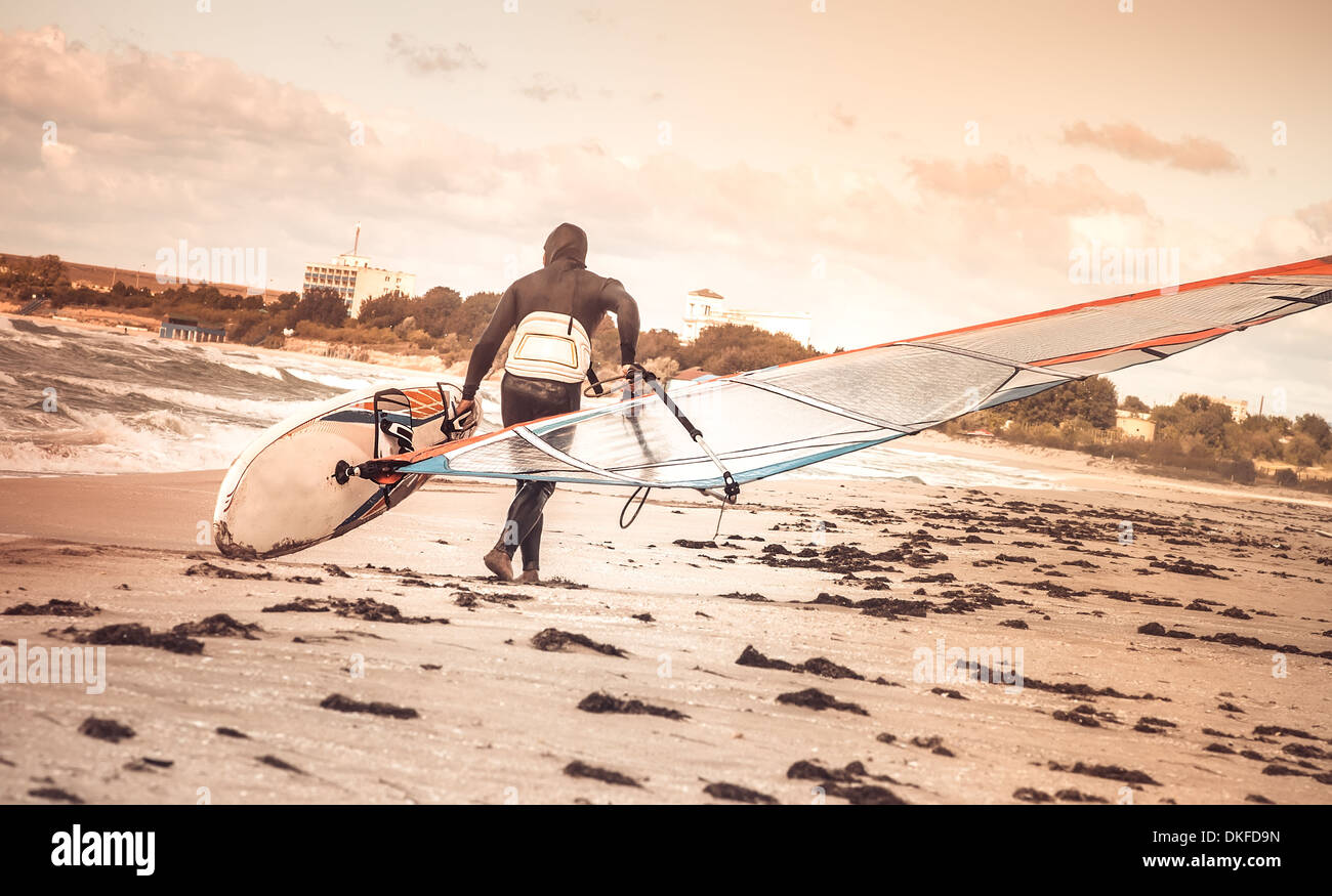 La windsurfista con junta en la playa Mar Vista posterior Mar Windsurf DEPORTE CONCEPTO DE ESTILO DE VIDA Foto de stock