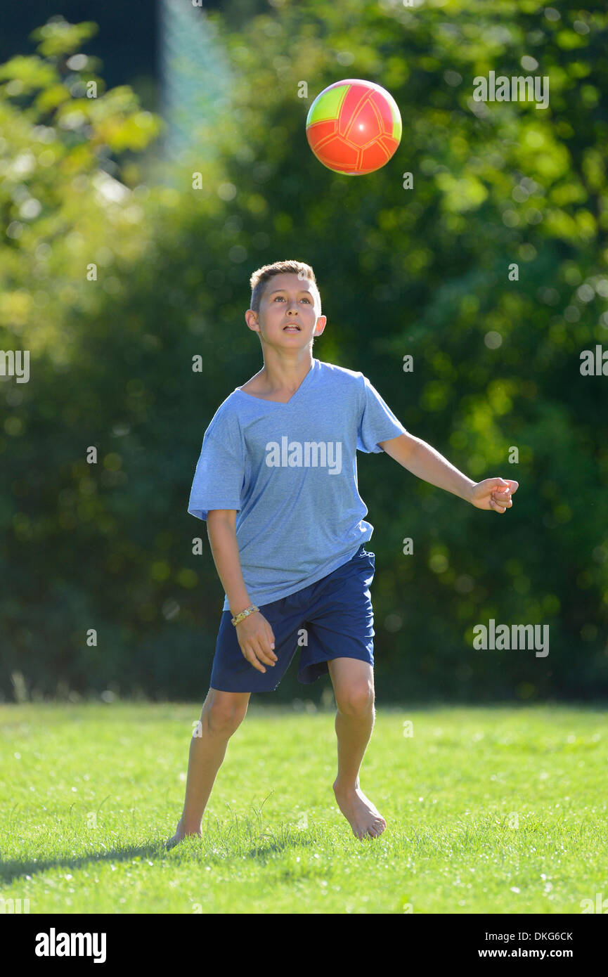 Adolescente jugando al fútbol en la pradera, el Alto Palatinado, Baviera, Alemania, Europa Foto de stock