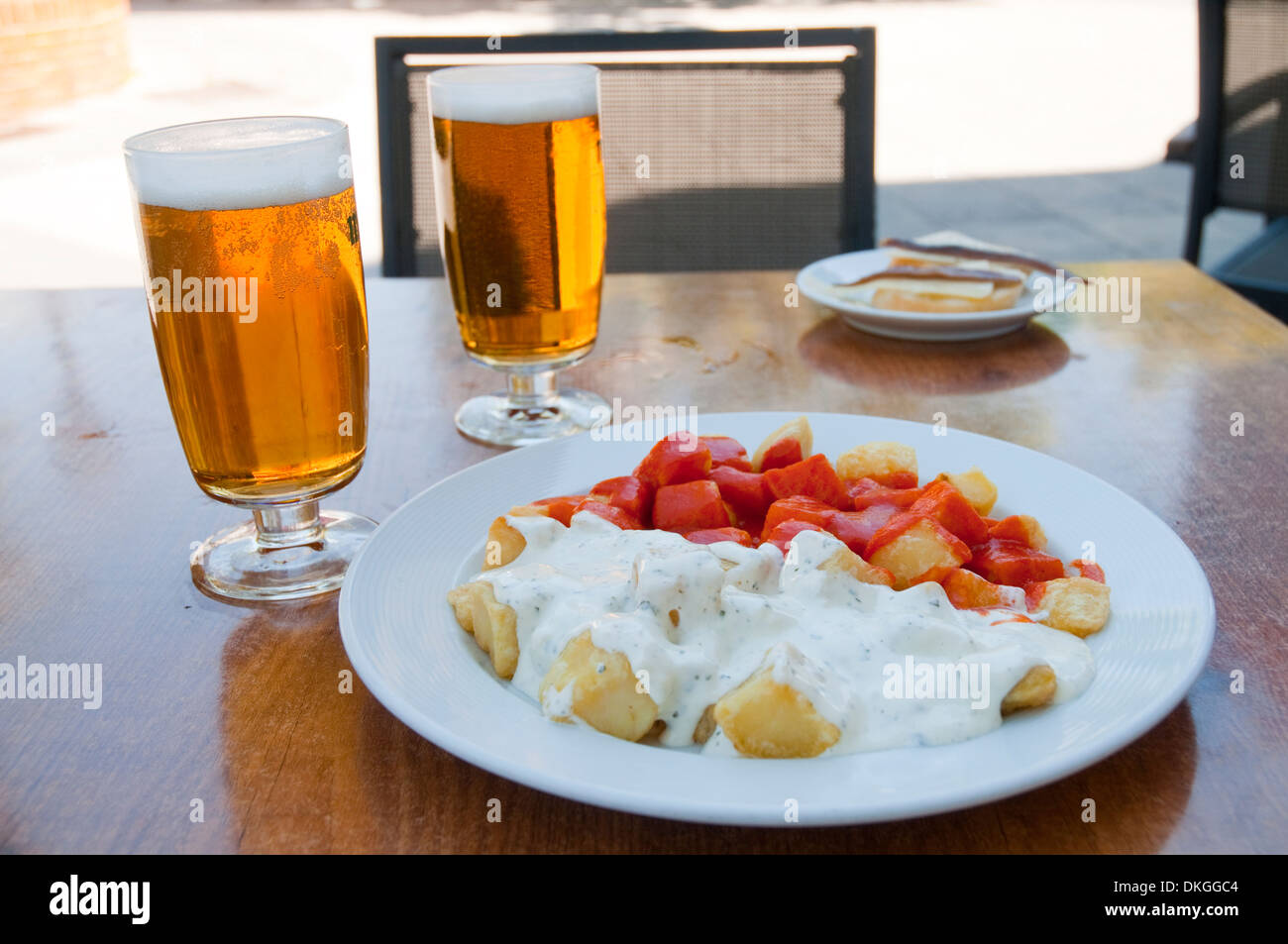Español aperitivo Patatas Bravas y alioli de patata con dos vasos de