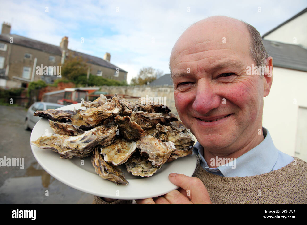 Oyster farmer Robert Graham con su gigas las ostras del Pacífico Foto de stock