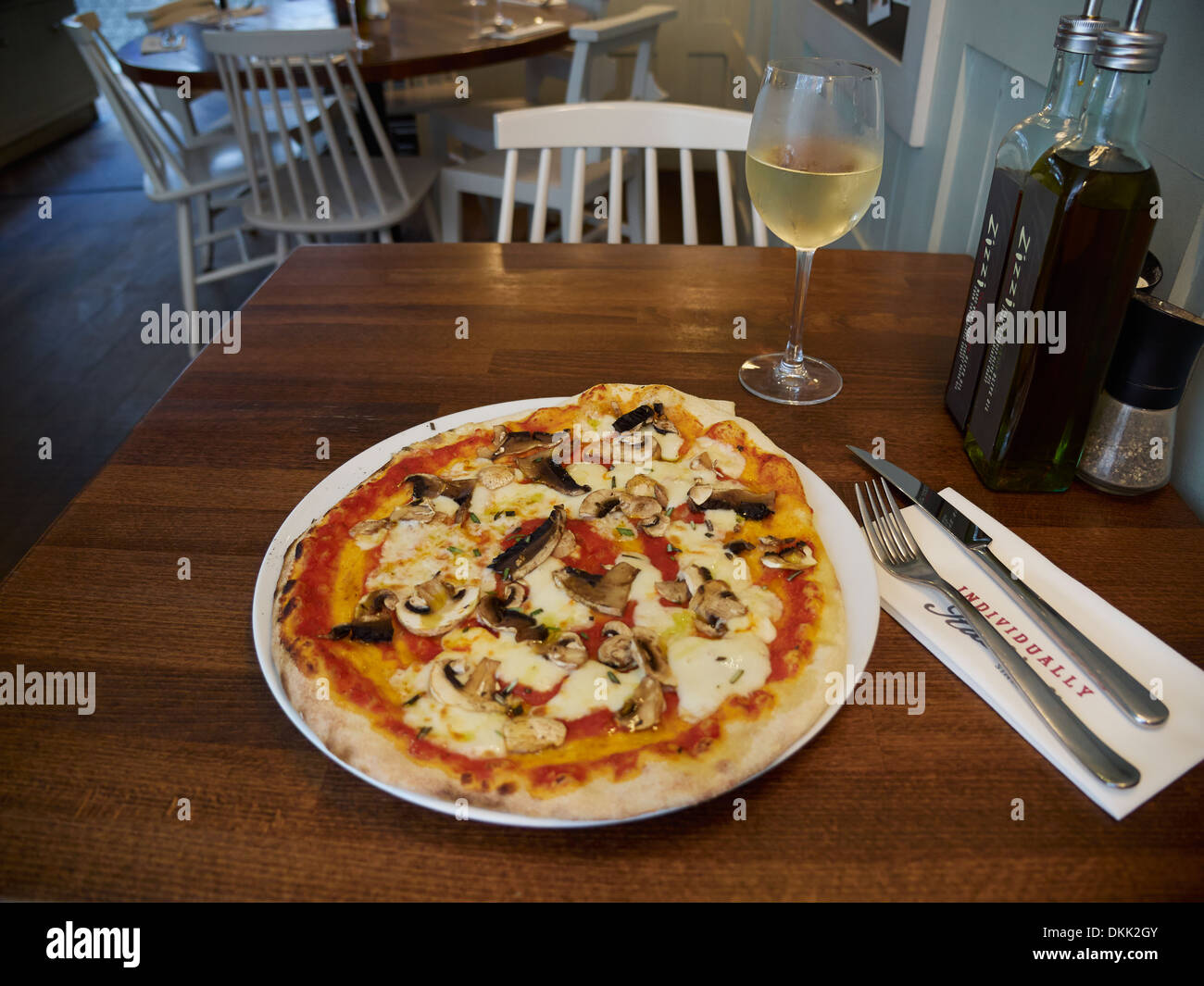 Pizza de setas con aceite de oliva fresco y un vaso de vino blanco Foto de stock
