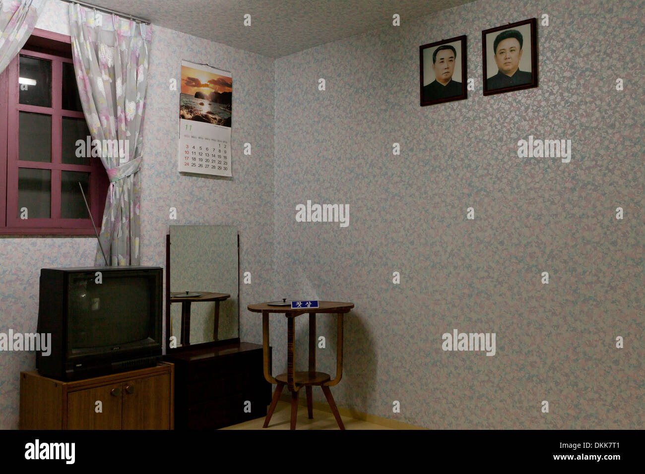 Maqueta del interior de la casa de la familia norcoreana que muestra retratos de Kim Il Sung y Kim Jong Il en la pared Foto de stock