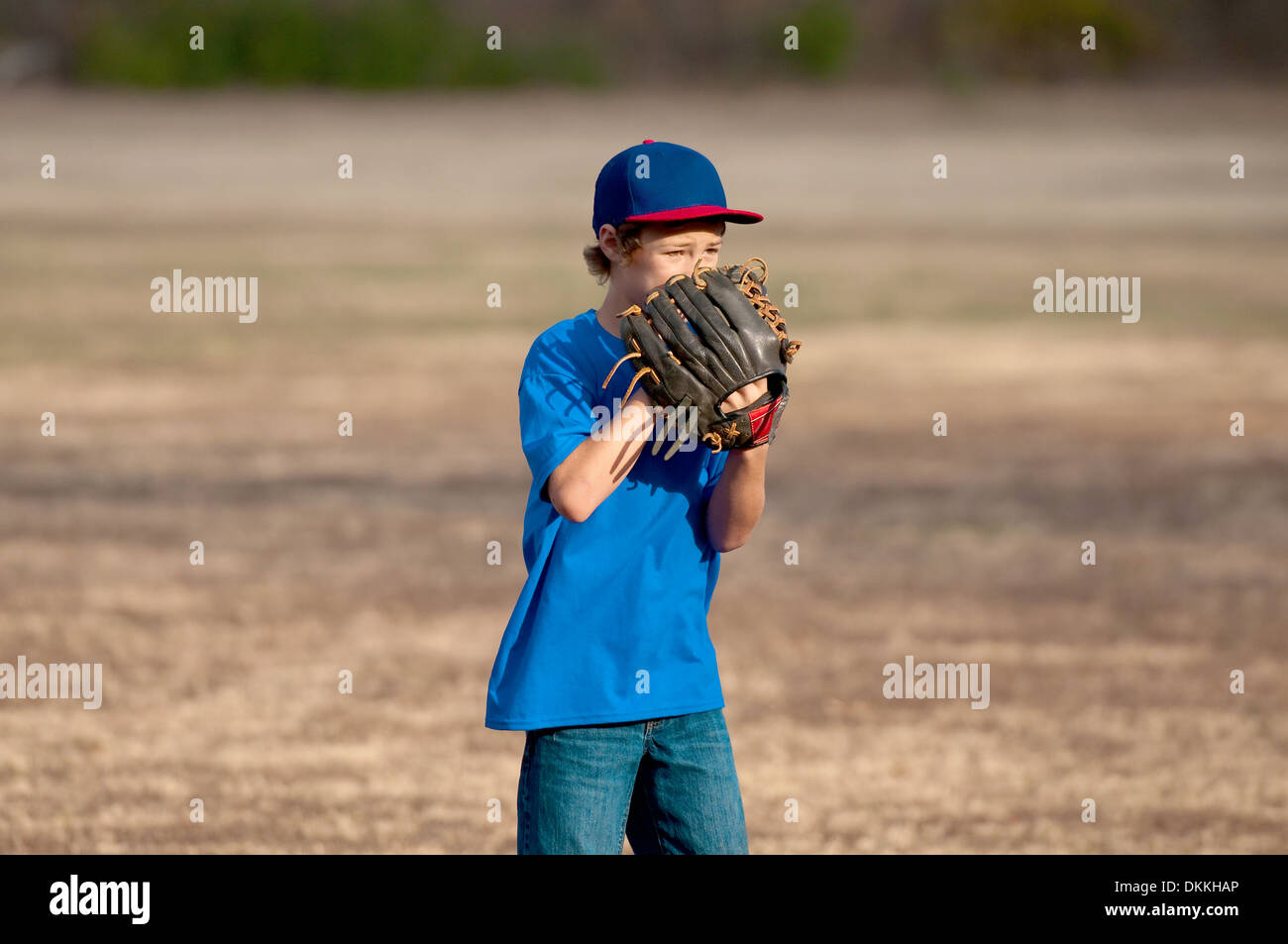 Chico lindo en un parque jugando béisbol. Foto de stock