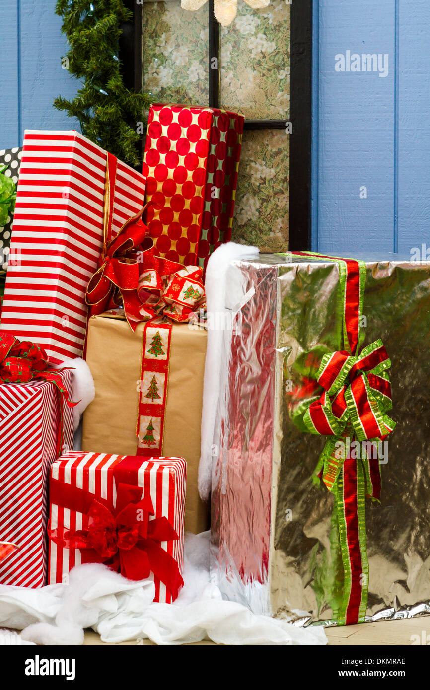 Grandes regalos envueltos en papeles coloridos con arcos en un montón listo  para Navidad Fotografía de stock - Alamy
