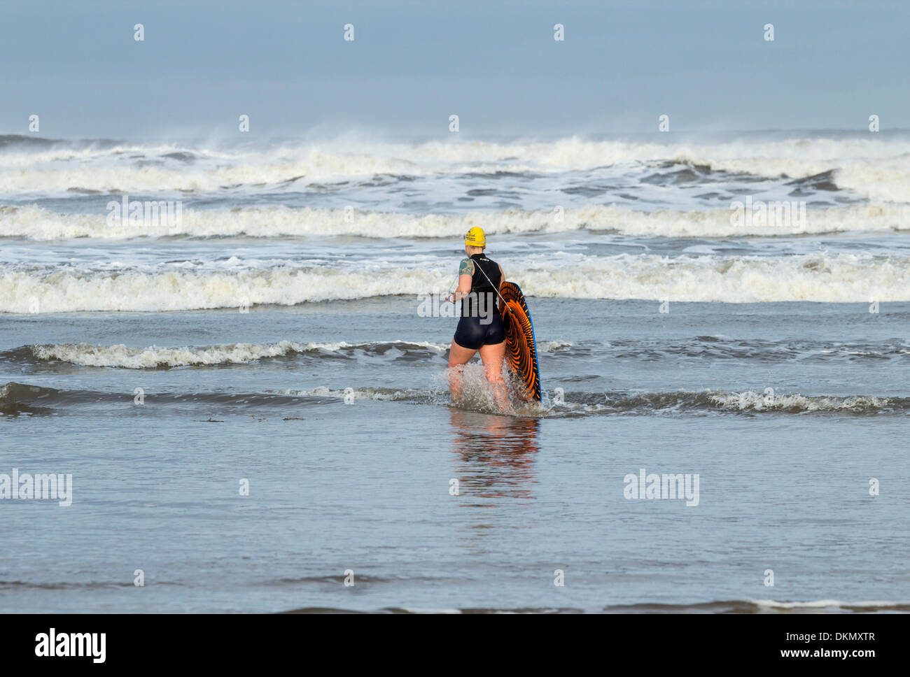 Cuerpo Femenino boarder sin traje de neopreno en invierno en Saltburn junto al mar, en la costa noreste de Inglaterra, Reino Unido. Foto de stock