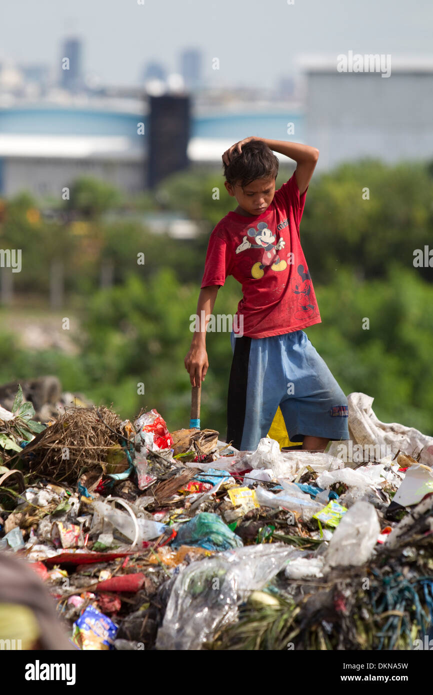 Un niño la compactación para nada de valor en el lugar de vertido de residuos Inayawan,en la Ciudad de Cebu, Filipinas Foto de stock