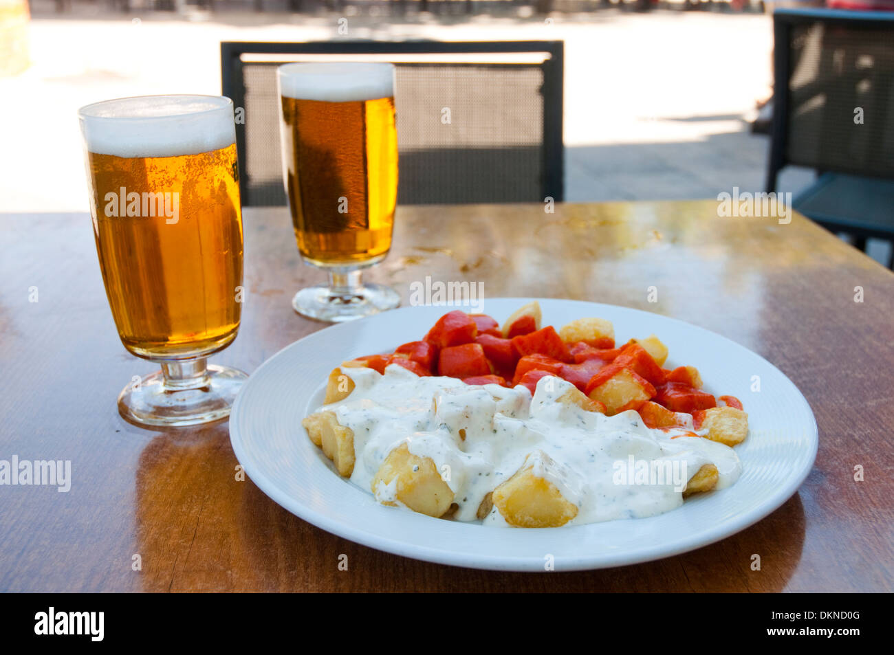 Español aperitivo Patatas Bravas y alioli de patata con dos vasos de