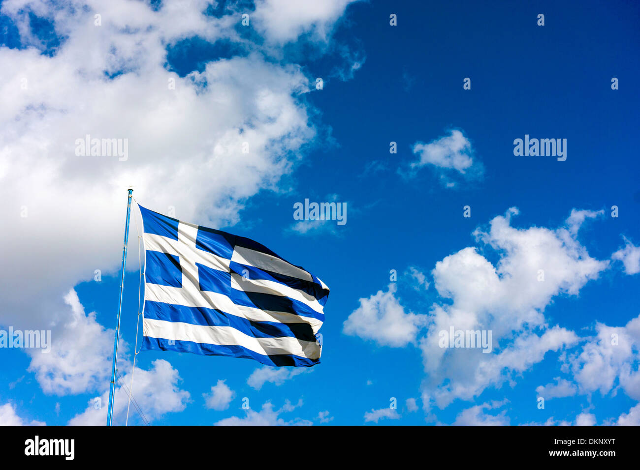Gran ondea la bandera griega contra el cielo azul con nubes blancas Foto de stock